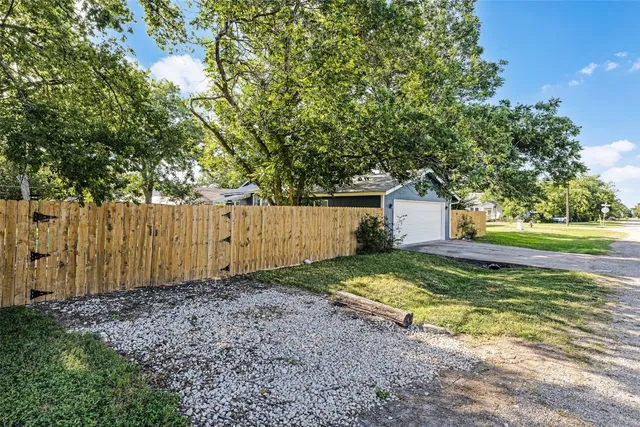 a view of a pathway of a yard with wooden fence