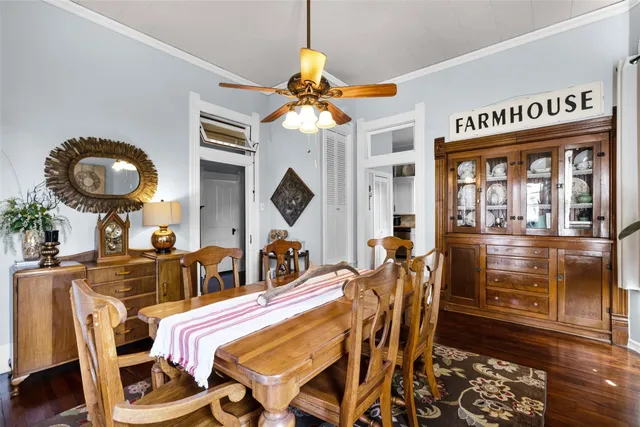 a dining room with wooden floor a chandelier a glass table and chairs