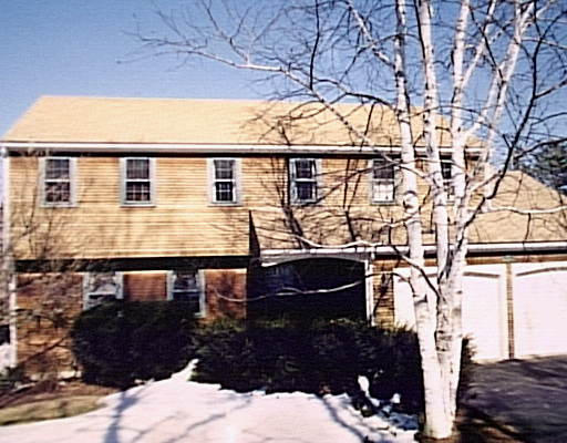 a front view of a house with large trees