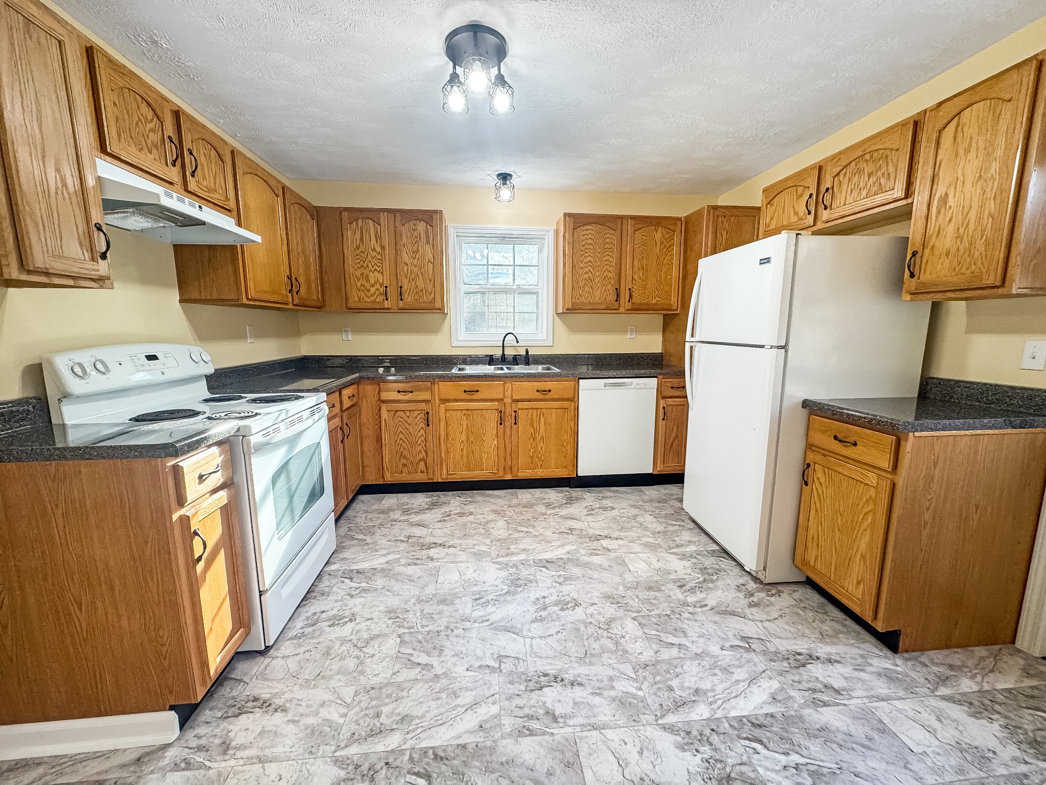 608 Big Rock Road Big Rock, TN 37023 - Photo 4 of 15 a kitchen with stainless steel appliances granite countertop a refrigerator a stove a sink dishwasher and wooden cabinets