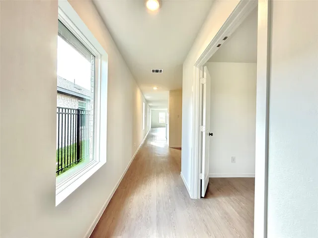 a view of a hallway with wooden floor and glass door