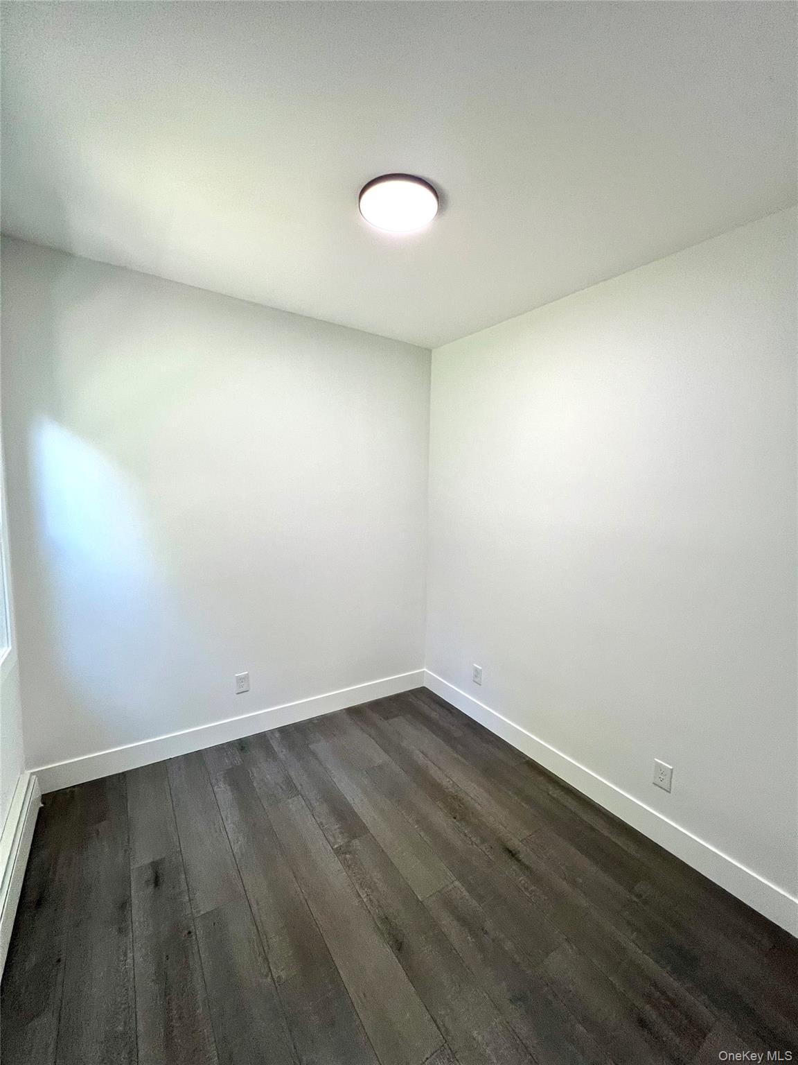 79 Orchard Street, Unit 2 Yonkers, NY 10703 - Photo 13 of 26 an empty room with wooden floor and windows