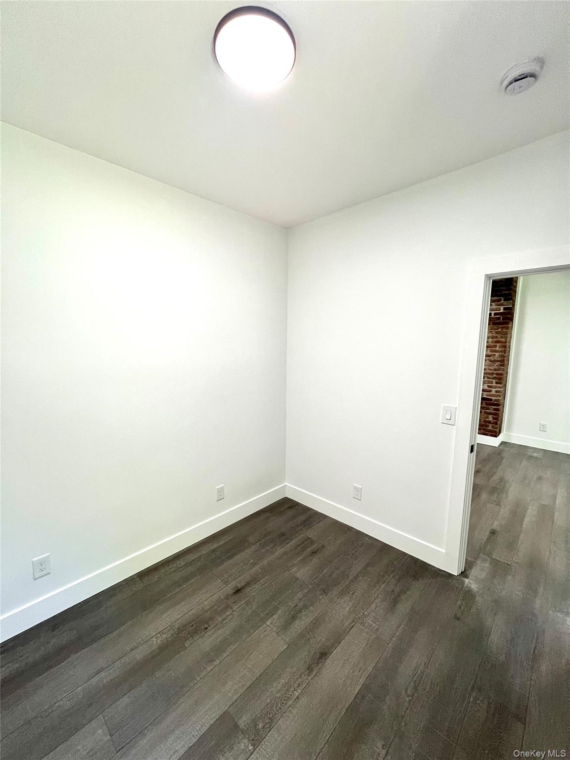 79 Orchard Street, Unit 2 Yonkers, NY 10703 - Photo 14 of 26 an empty room with wooden floor and windows