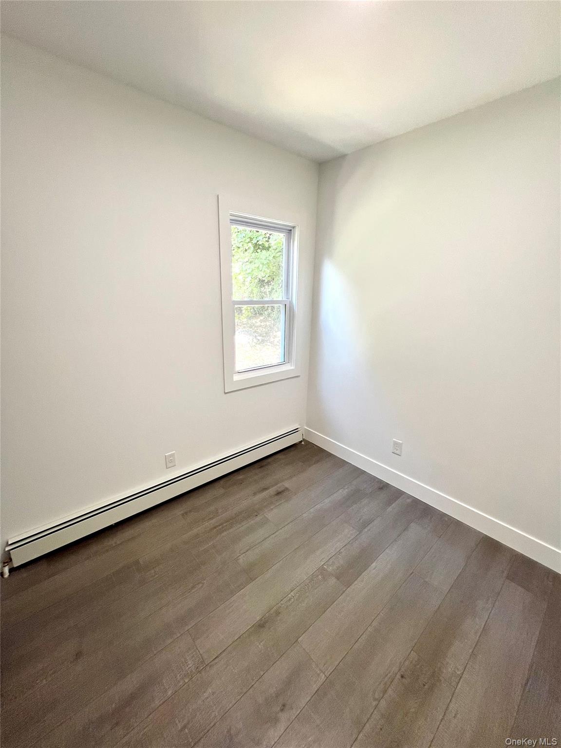 79 Orchard Street, Unit 2 Yonkers, NY 10703 - Photo 15 of 26 an empty room with wooden floor and windows