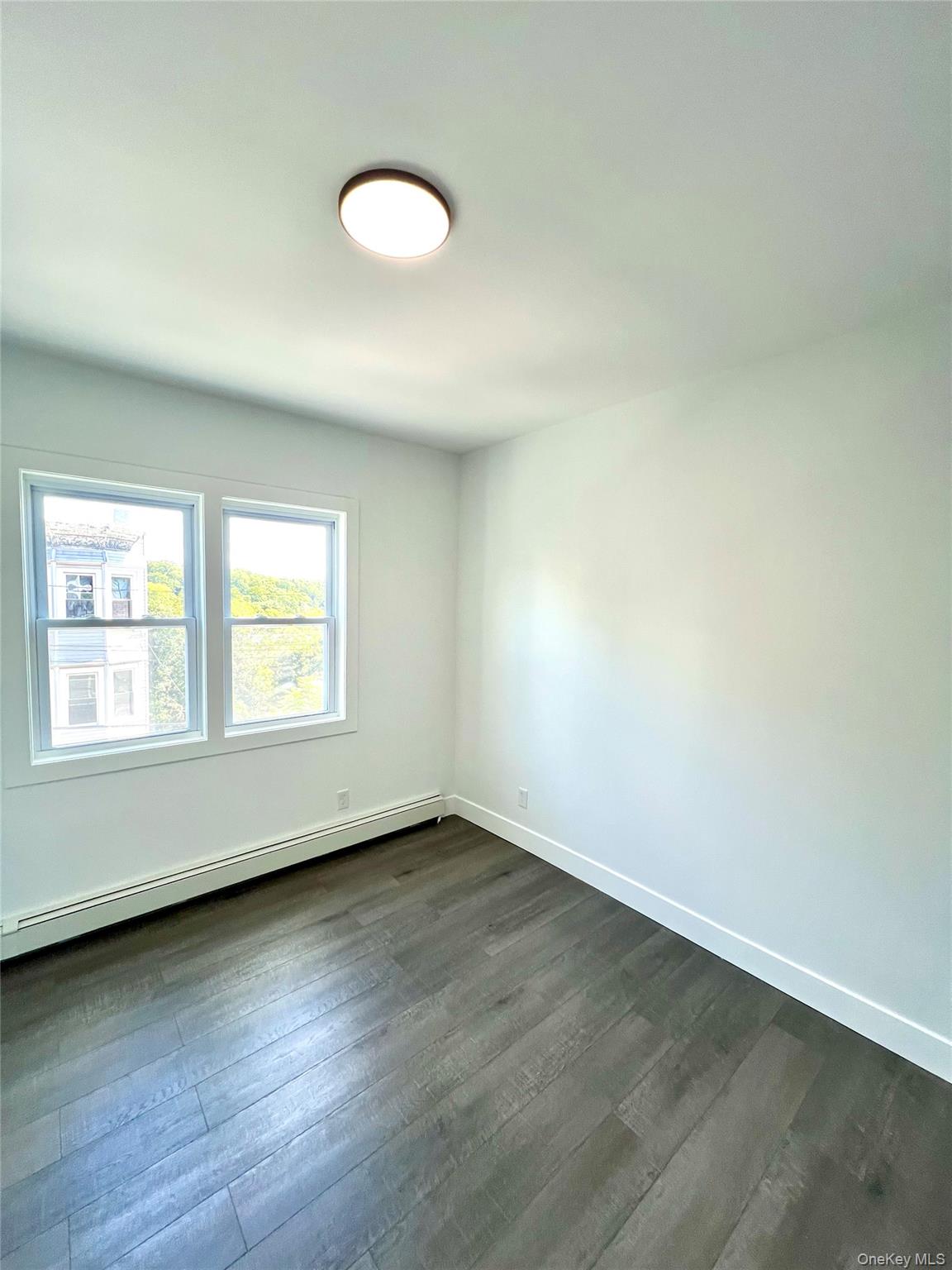 79 Orchard Street, Unit 2 Yonkers, NY 10703 - Photo 18 of 26 an empty room with wooden floor and windows