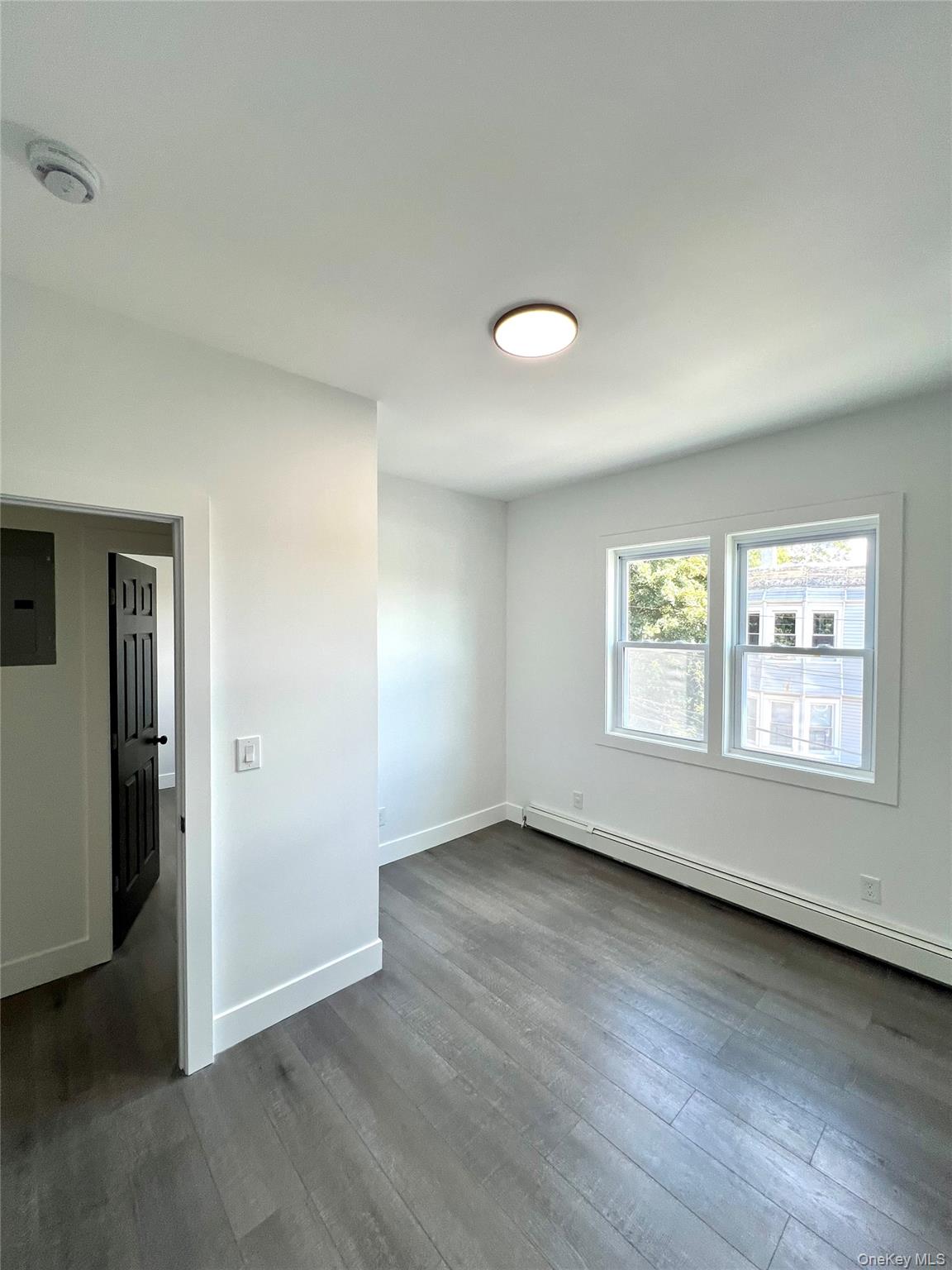 79 Orchard Street, Unit 2 Yonkers, NY 10703 - Photo 19 of 26 an empty room with wooden floor and windows