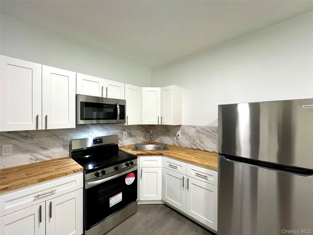 a kitchen with stainless steel appliances white cabinets and a refrigerator