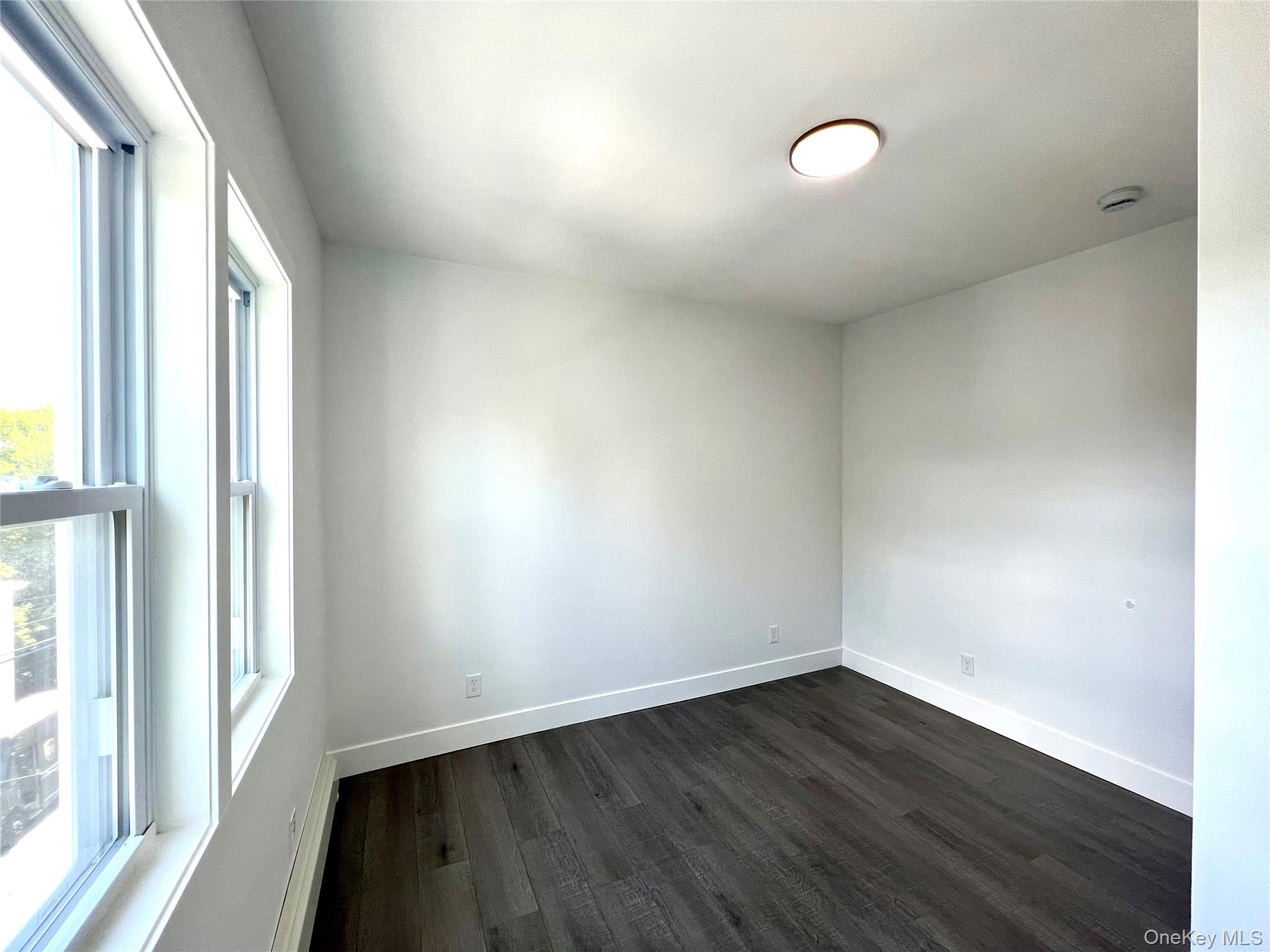 79 Orchard Street, Unit 2 Yonkers, NY 10703 - Photo 25 of 26 a view of an empty room with wooden floor and a window