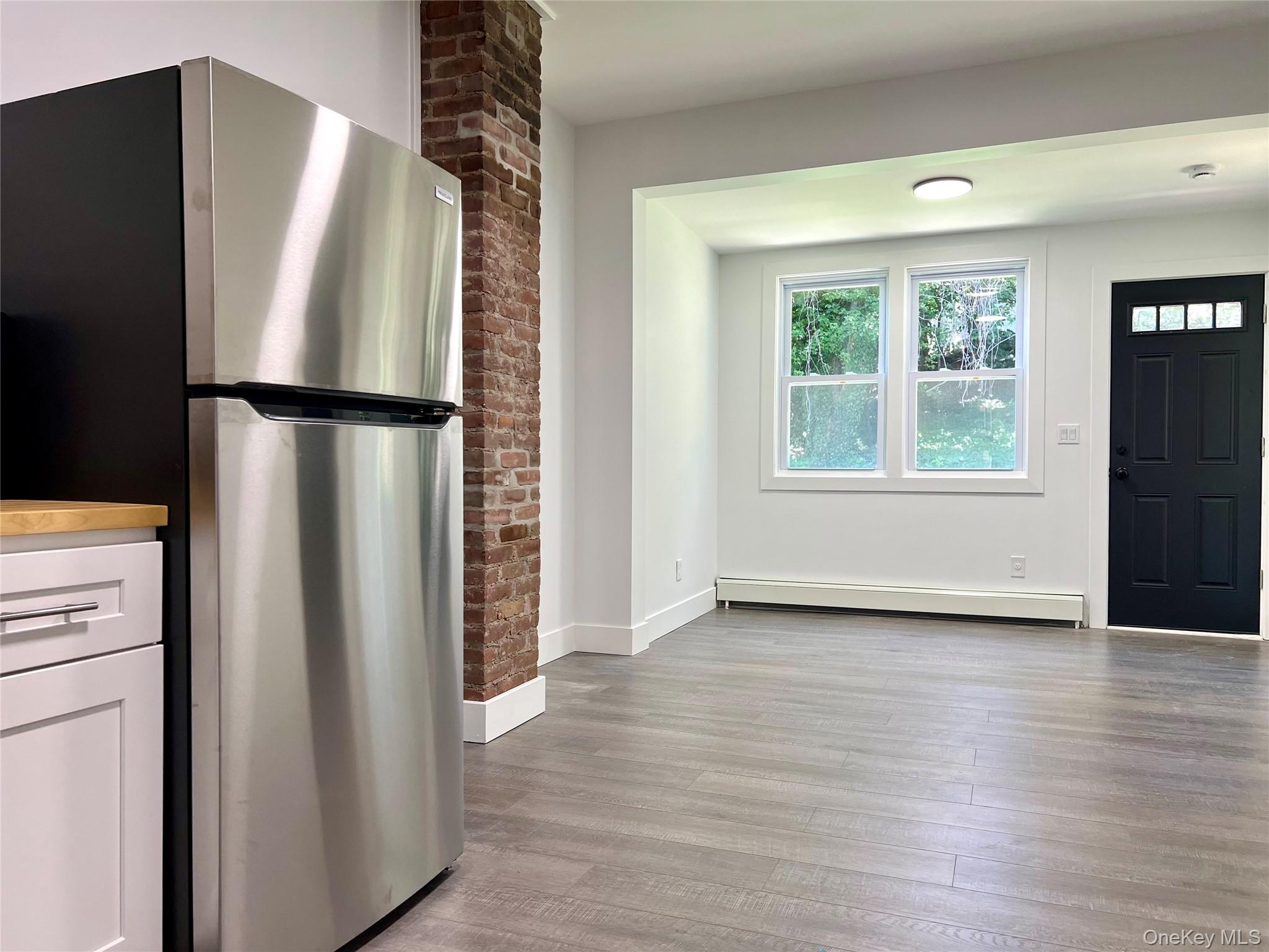 79 Orchard Street, Unit 2 Yonkers, NY 10703 - Photo 5 of 26 a view of a kitchen with wooden floor and a refrigerator