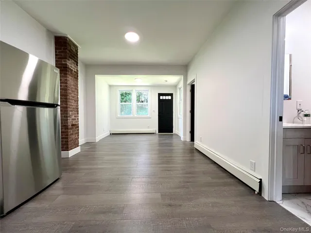 a view of a kitchen with a refrigerator and wooden floor