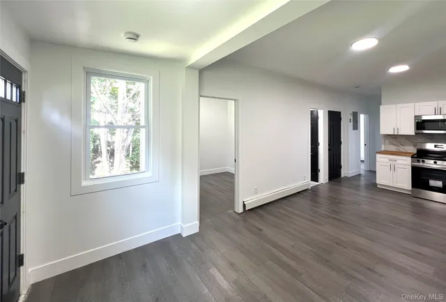 a view of empty room with wooden floor and window