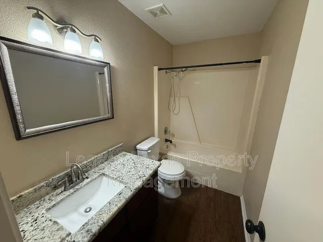 a bathroom with a sink a toilet and mirror