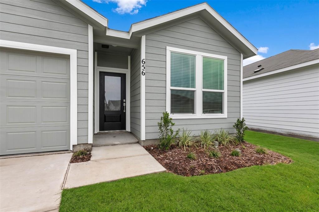656 Waymaker Way Princeton, TX 75407 - Photo 2 of 40 Contemporary exterior featuring light gray horizontal siding, a black front door with a glass panel, and white trim
