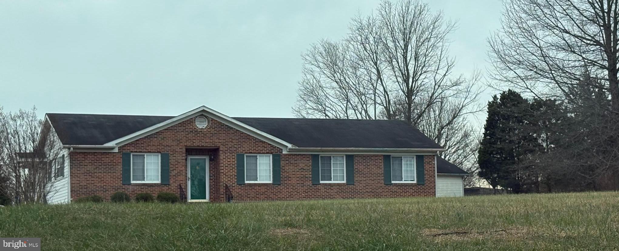 a front view of a house with a yard and trees