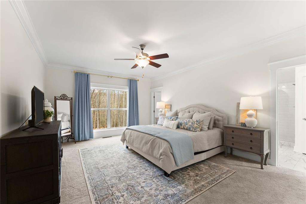 6998 Britt Gailey Road Clermont, GA 30527 - Photo 30 of 92 a spacious bedroom with a bed a dresser and a chandelier