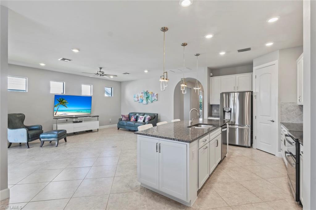 19902 Beverly Park Road Estero, FL 33928 - Photo 47 of 47 Kitchen with open floor plan, pendant lighting, appliances with stainless steel finishes, white cabinetry, and dark stone countertops