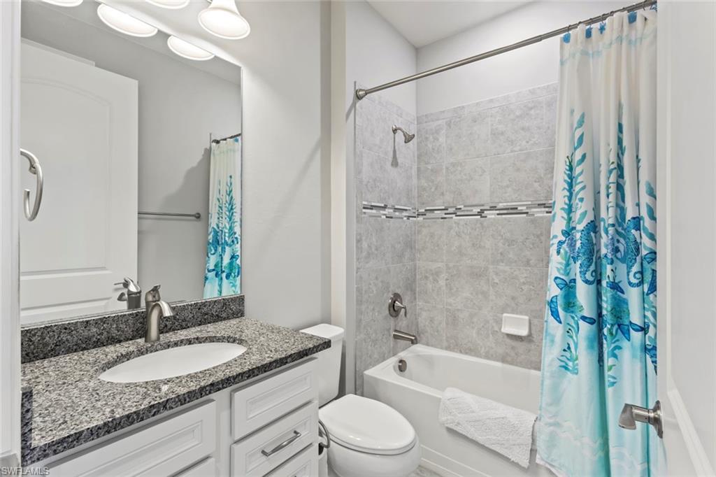 19902 Beverly Park Road Estero, FL 33928 - Photo 17 of 47 Bathroom featuring shower / tub combo with curtain and vanity