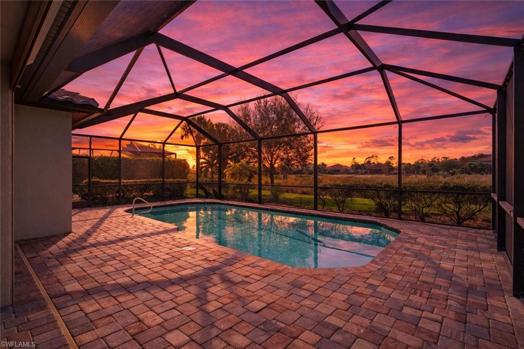 19902 Beverly Park Road Estero, FL 33928 - Photo 2 of 47 Outdoor pool with a sunroom, glass enclosure, and a patio area