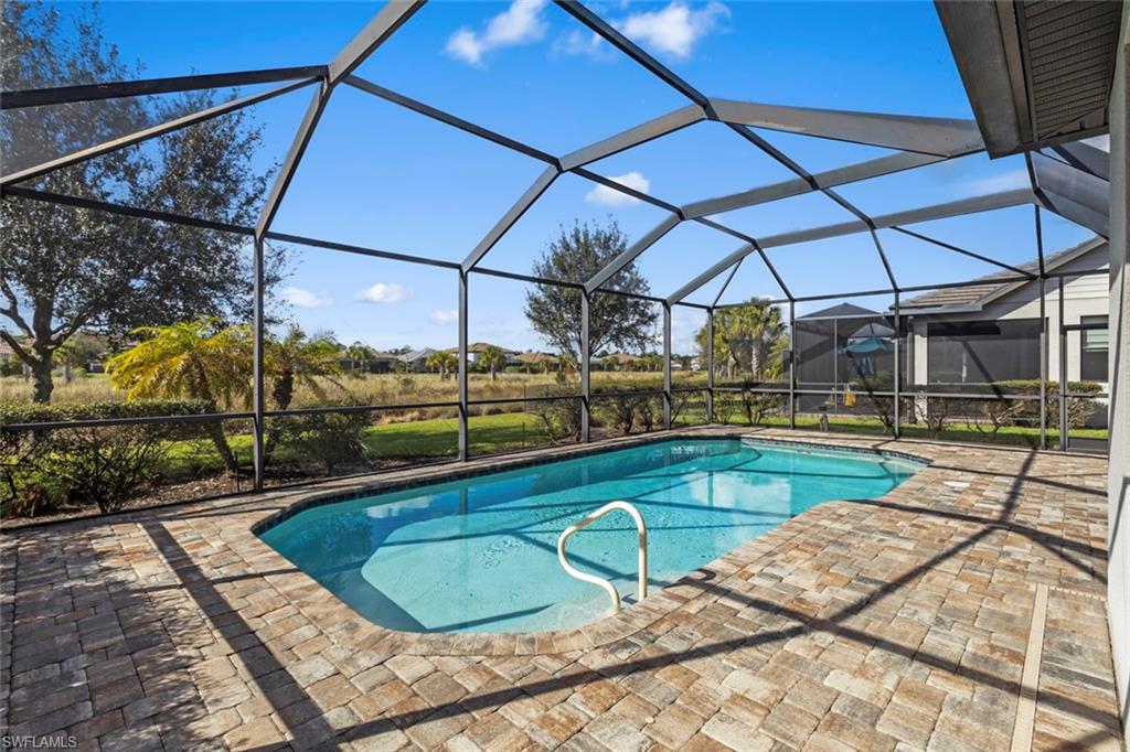 19902 Beverly Park Road Estero, FL 33928 - Photo 22 of 47 Outdoor pool with glass enclosure, a sunroom, and a patio