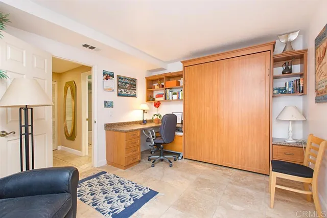a view of a workspace with furniture and a window