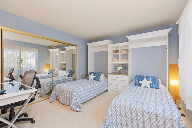 a bedroom with two beds and large windows