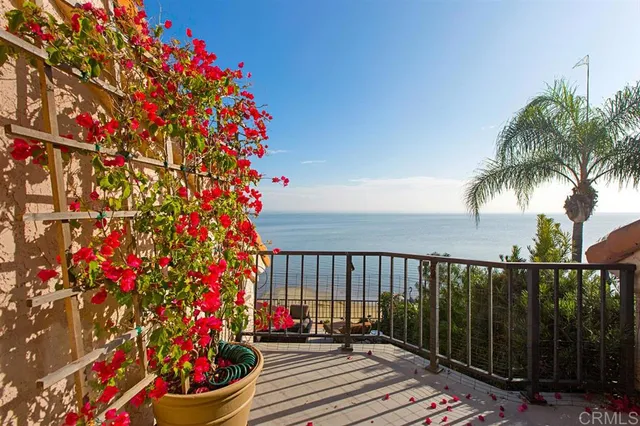a view of a flower garden with wooden fence