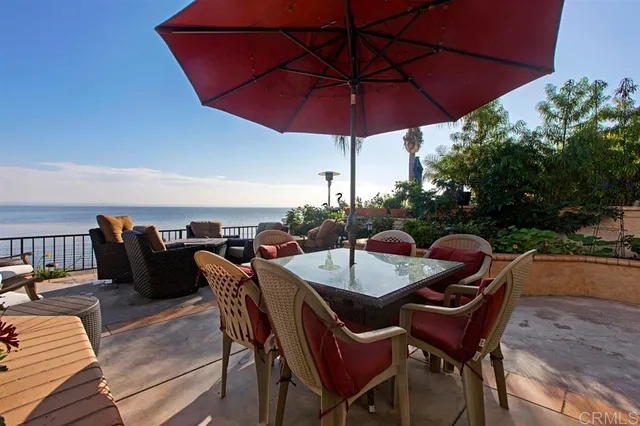 a view of a patio with a table and chairs under an umbrella