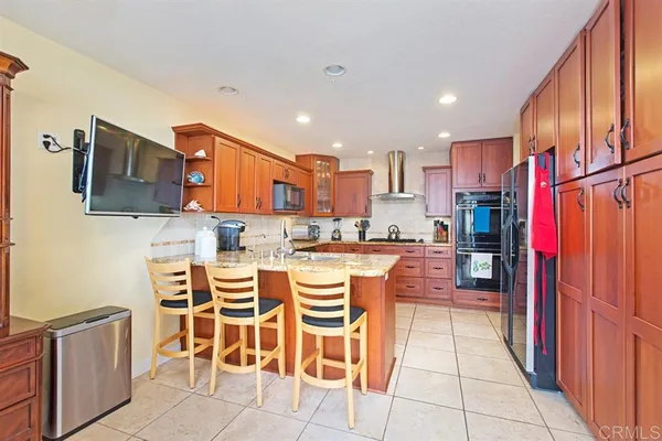 a kitchen with stainless steel appliances kitchen island granite countertop a refrigerator and cabinets