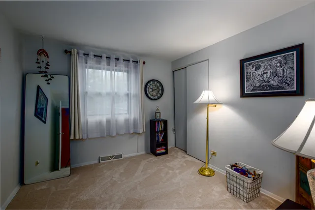 a view of an empty room with closet and a window