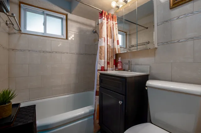 a bathroom with a sink toilet vanity and tub
