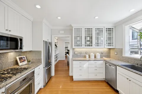 a kitchen with appliances a refrigerator a stove and cabinets