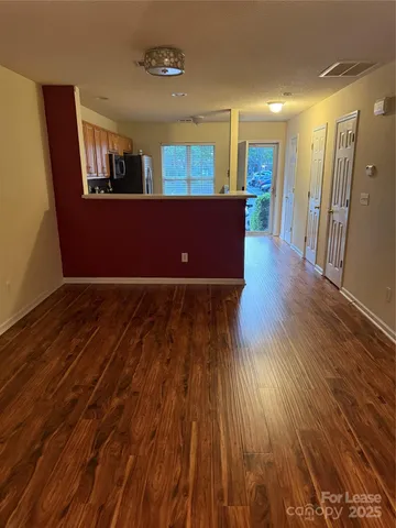 a view of a room with wooden floor and furniture