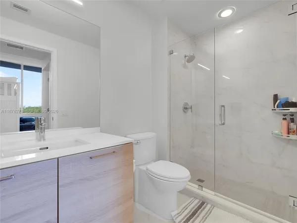 a bathroom with a sink a toilet and shower