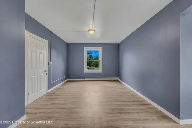 a view of room with window and wooden floor