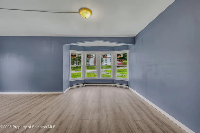 a view of a room with wooden floor and window