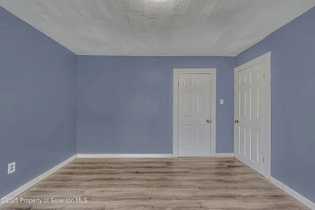 an empty room with windows and a fireplace