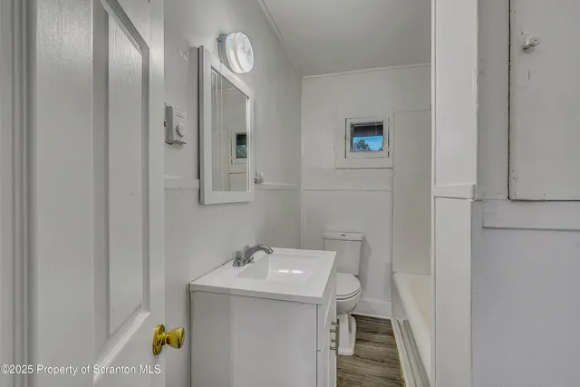 a view of a room with wooden floor and entryway