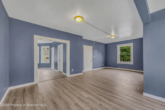 a view of a room with wooden floor and window