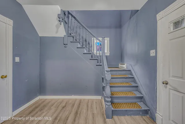 a view of entryway and hall with wooden floor