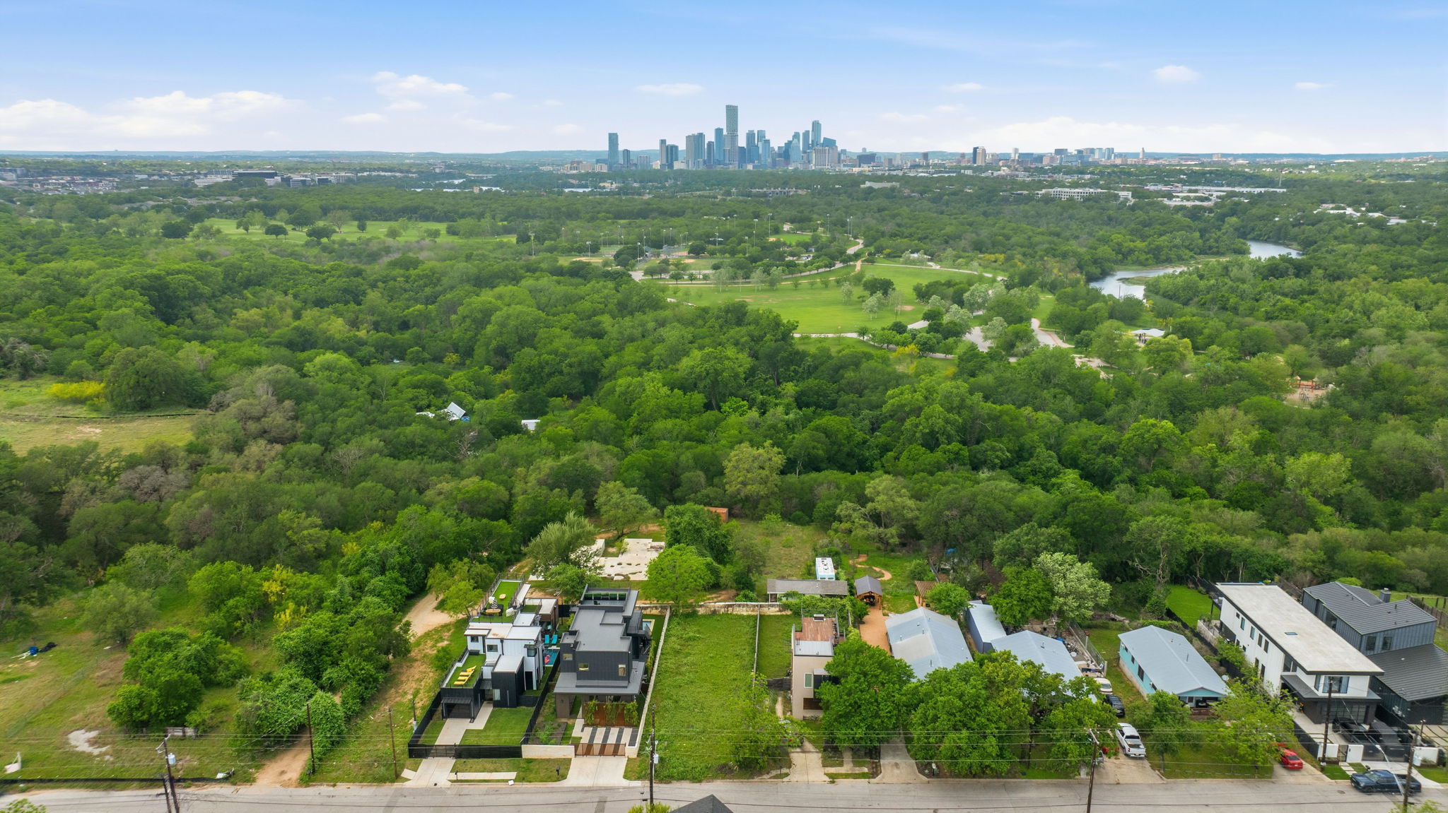 416 Kemp Street Austin, TX 78741 - Photo 14 of 14 This aerial view showcases the property's location amidst extensive greenery, with a distant cityscape visible