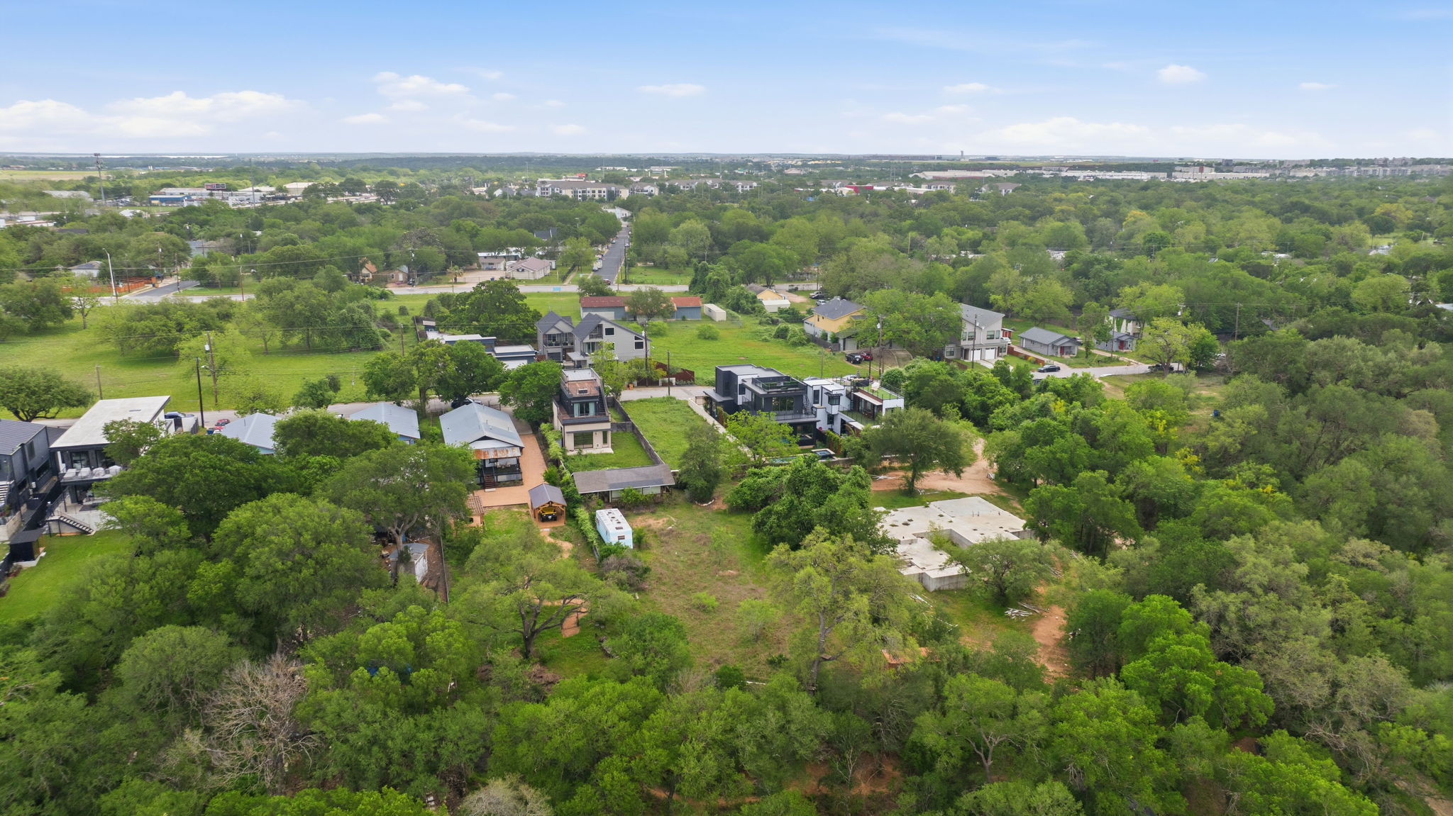416 Kemp Street Austin, TX 78741 - Photo 6 of 14 Expansive aerial view showcasing the property's surroundings, characterized by abundant mature trees and residential structures