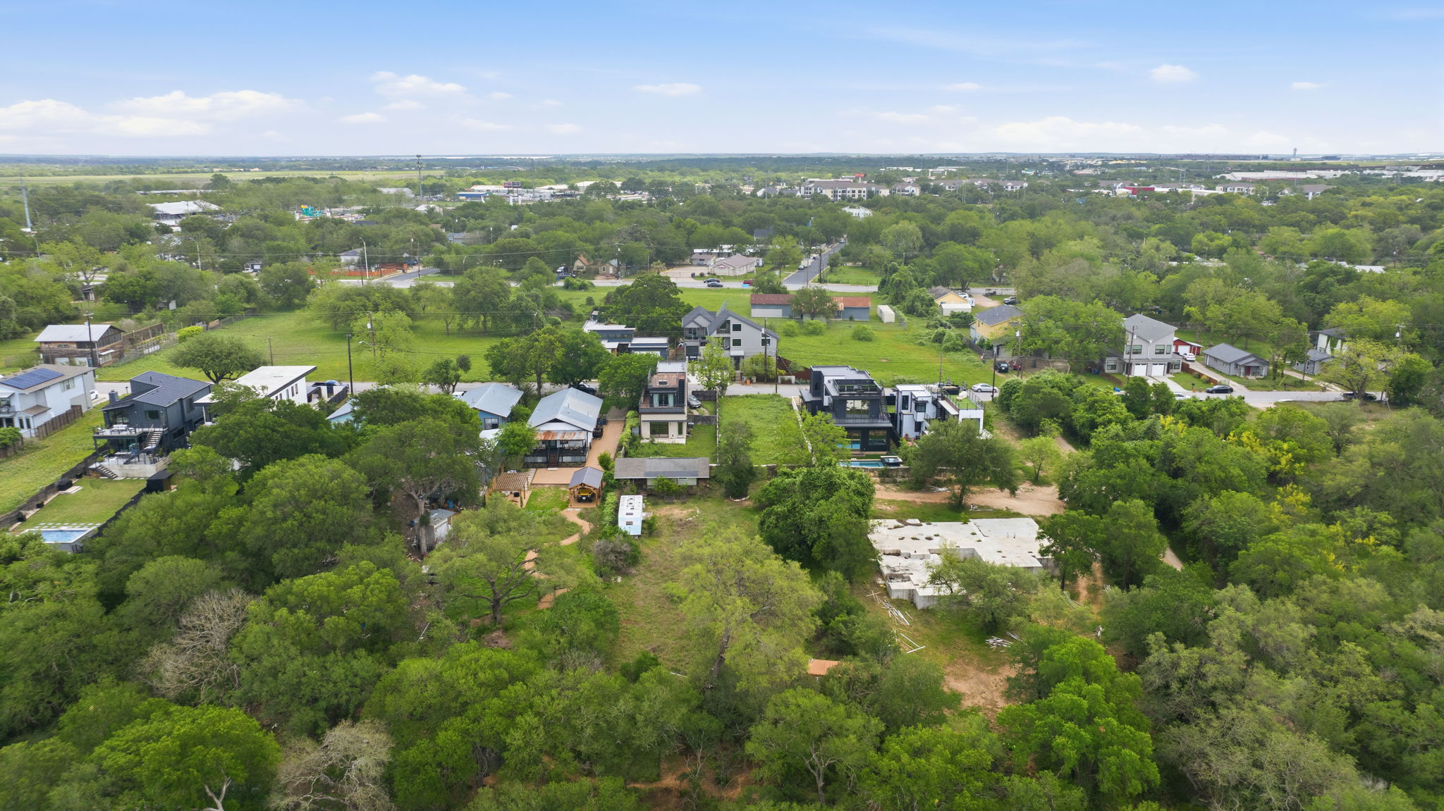 416 Kemp Street Austin, TX 78741 - Photo 7 of 14 Expansive aerial view of the property and its surrounding area, featuring numerous mature trees and a clear blue sky