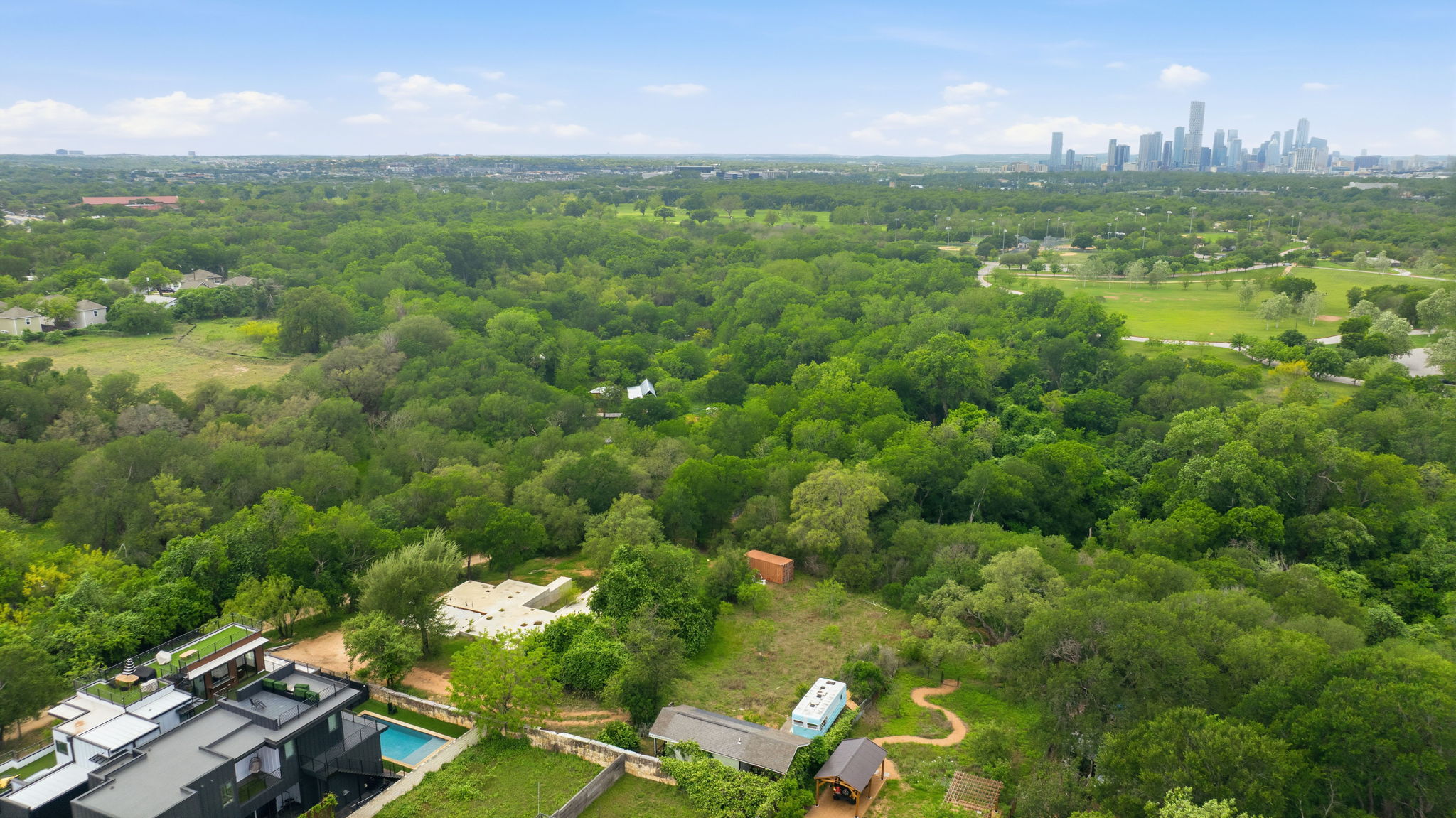 416 Kemp Street Austin, TX 78741 - Photo 8 of 14 Aerial view showcasing the property's modern architecture, a swimming pool, and extensive surrounding greenery