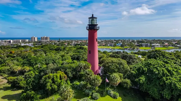 an aerial view of residential houses with outdoor space and trees