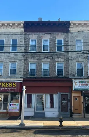 a front view of a building with glass windows and a street
