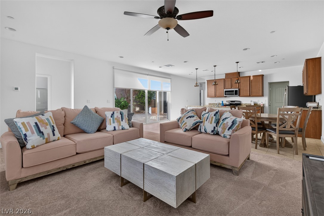 1100 East Sunset Road Henderson, NV 89011 - Photo 8 of 58 An open-concept living space seamlessly connects the living room, dining area, and kitchen, creating an ideal setting for both relaxation and entertaining.