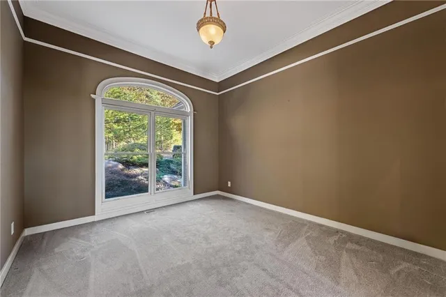 an empty room with a ceiling fan and window