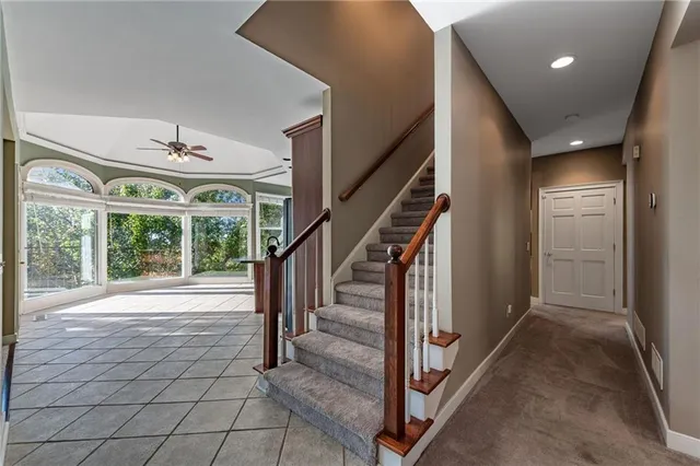 a view of an empty room with a chandelier fan