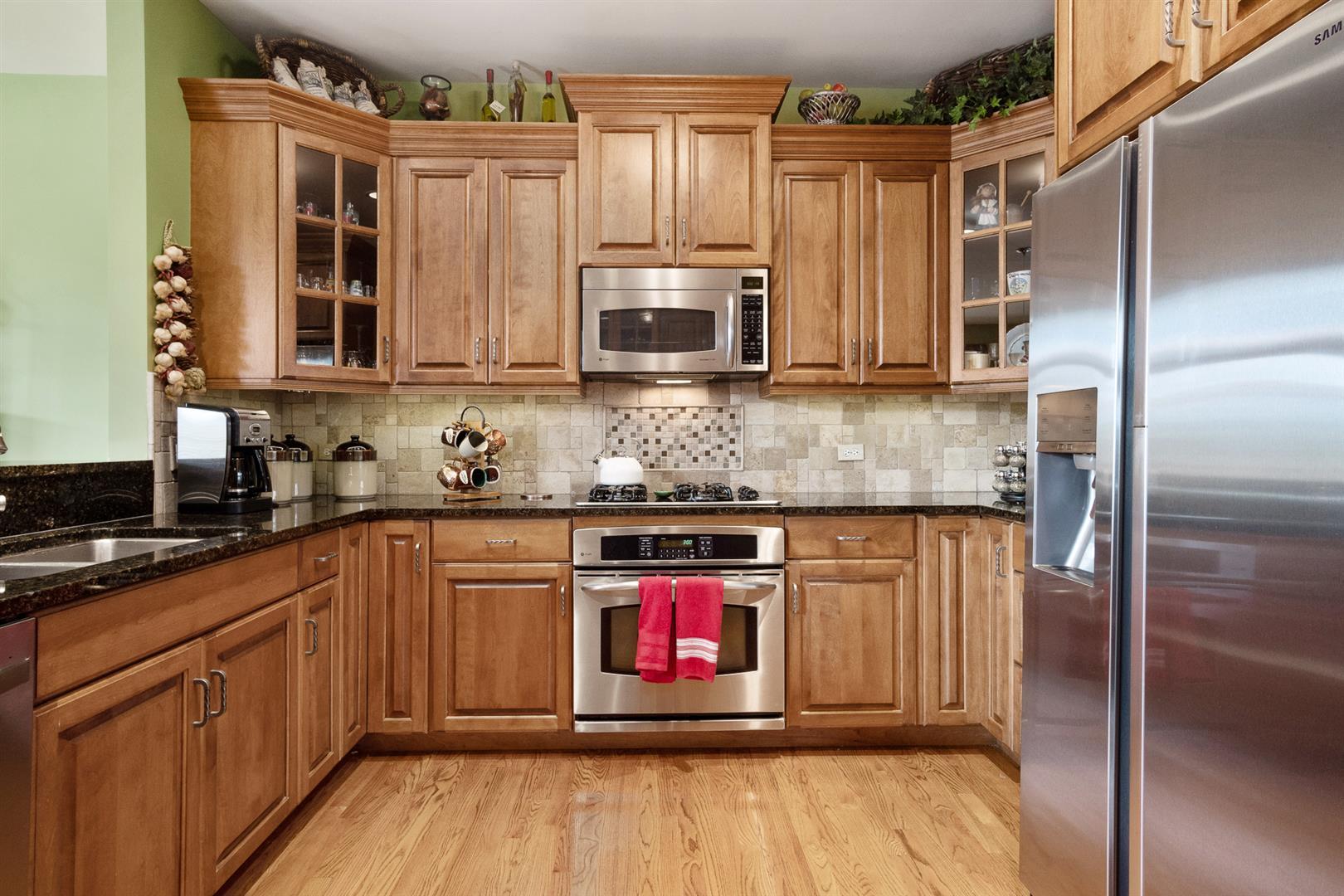 3705 Ridge Pointe Drive Geneva, IL 60134 - Photo 12 of 35 a kitchen with stainless steel appliances granite countertop a stove a sink and a microwave
