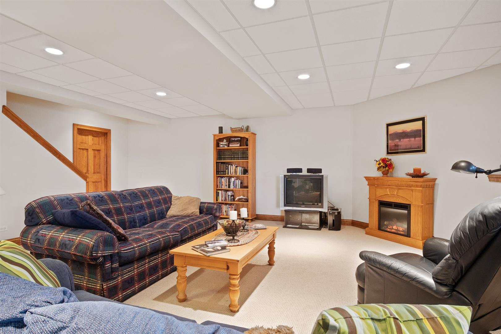 3705 Ridge Pointe Drive Geneva, IL 60134 - Photo 30 of 35 a living room with furniture a fireplace and a flat screen tv